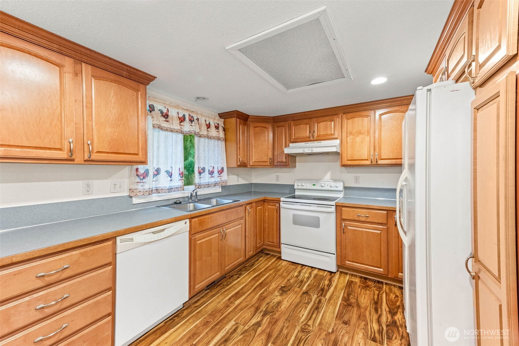 8529 37th Court Southeast Lacey, WA 98503 - Photo 10 of 34 a kitchen with stainless steel appliances granite countertop wooden cabinets a sink and a granite counter tops with a large window