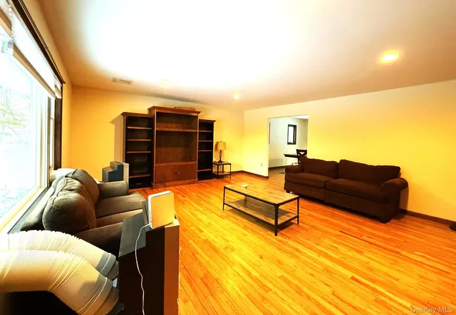 a living room with furniture a flat screen tv and a large window