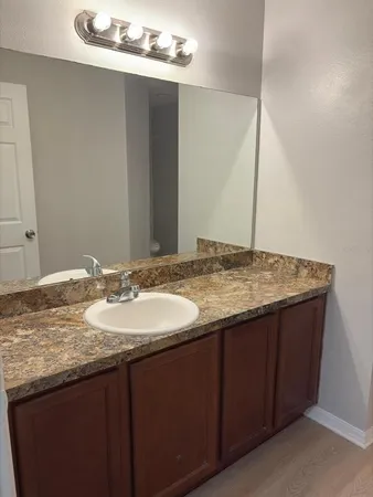 a bathroom with a granite countertop sink and a mirror