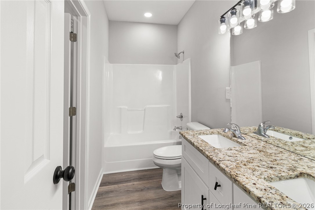 802 Holmes Street Clinton, NC 28328 - Photo 14 of 31 a bathroom with a granite countertop sink toilet a mirror and shower