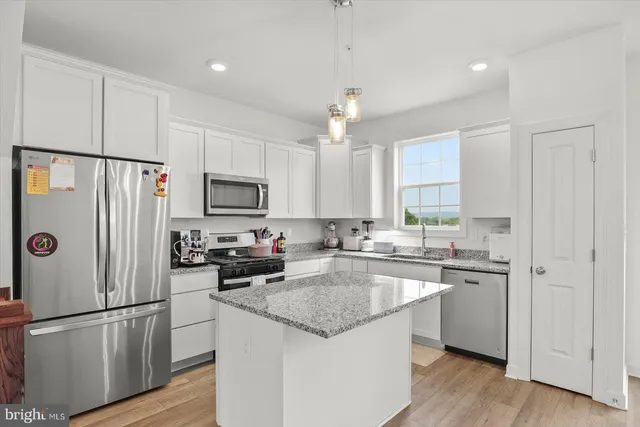 a kitchen with stainless steel appliances granite countertop a sink stove and cabinets