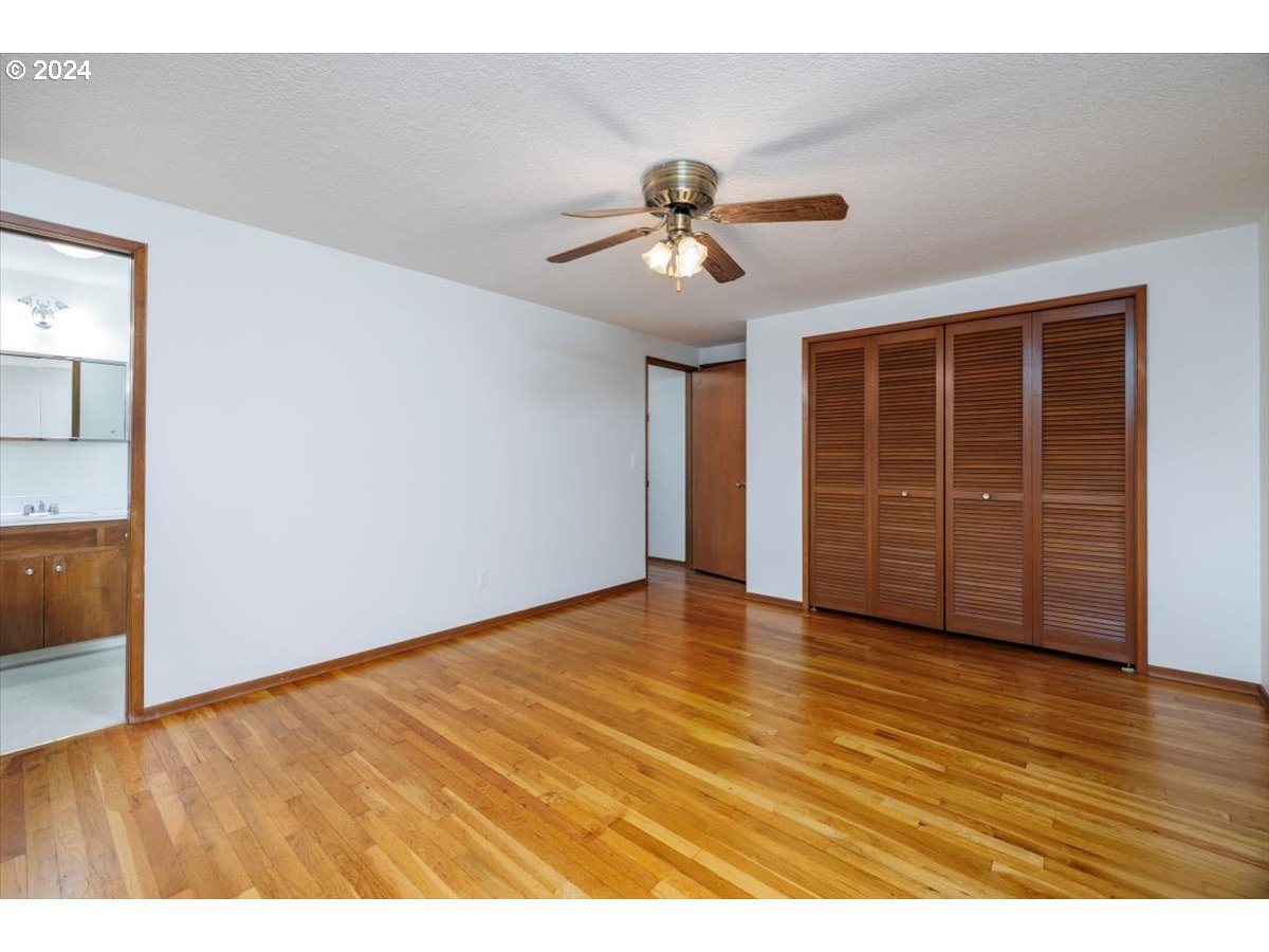 13400 Northwest Northrup Street Portland, OR 97229 - Photo 18 of 39 a view of an empty room with wooden floor and a ceiling fan