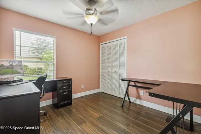 a view of a workspace with furniture and a window