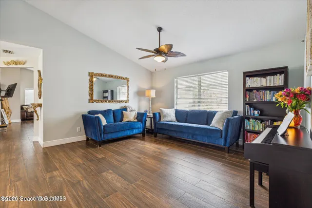 a living room with furniture and a wooden floor