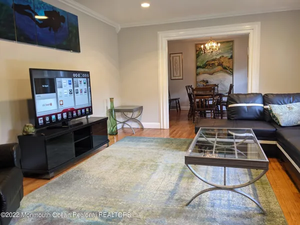 a living room with furniture a piano and a flat screen tv