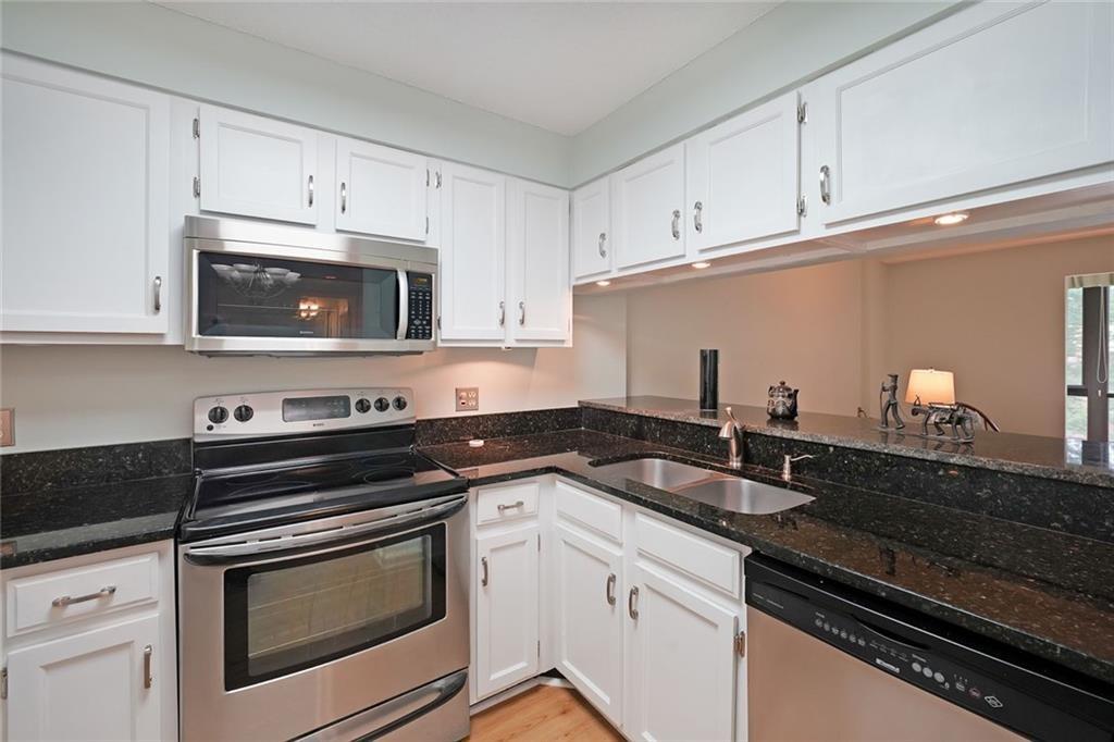 1800 Clairmont Lake, Unit A313 Decatur, GA 30033 - Photo 3 of 40 a kitchen with granite countertop white cabinets stainless steel appliances and a sink