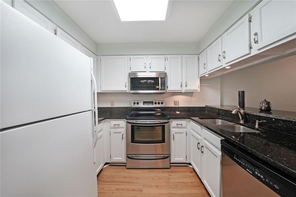 1800 Clairmont Lake, Unit A313 Decatur, GA 30033 - Photo 4 of 40 a kitchen with granite countertop a stove sink and cabinets