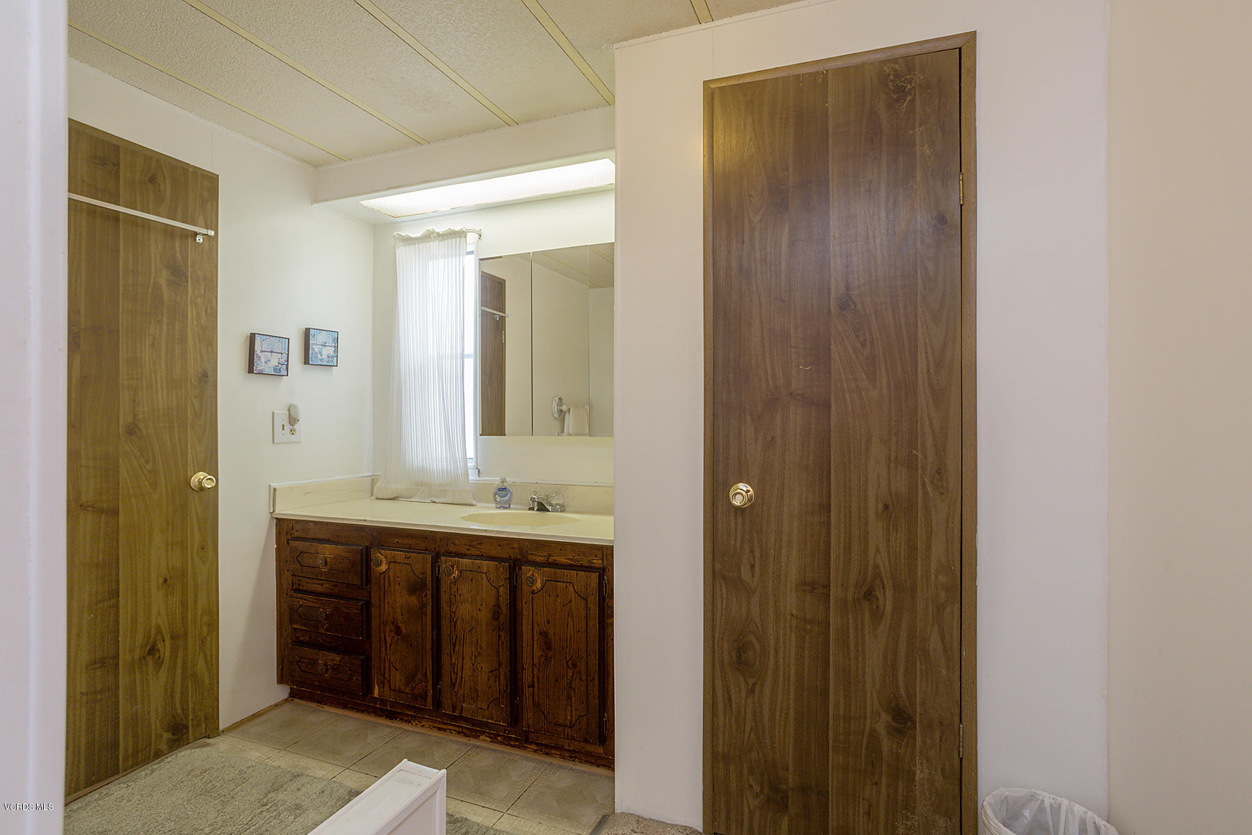 6480 Katherine Road, Unit 3 Simi Valley, CA 93063 - Photo 17 of 28 a bathroom with a granite countertop sink and a mirror