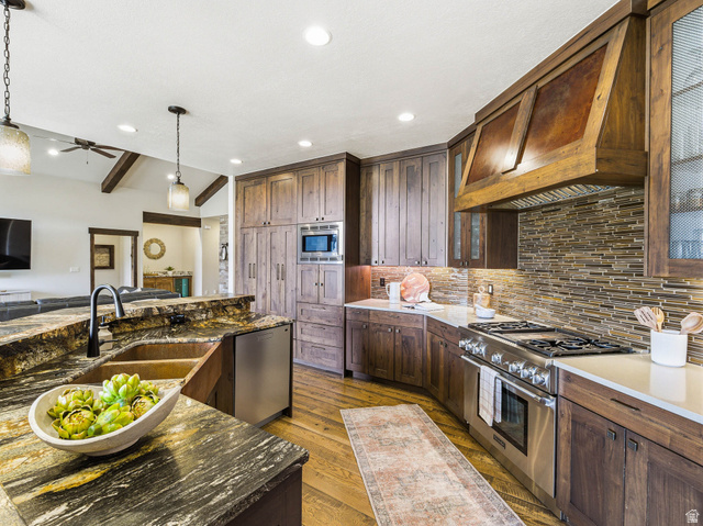 402 Shadow Hill Road Wanship, UT 84017 - Photo 15 of 90 Kitchen with vaulted ceiling with beams, dark stone countertops, ceiling fan, stainless steel appliances, and light wood finished floors
