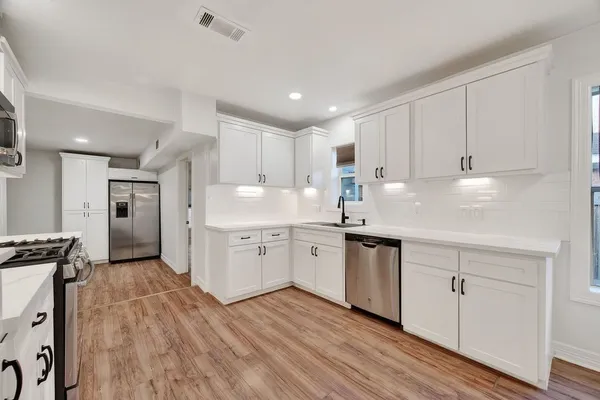 a kitchen with granite countertop white cabinets and white appliances