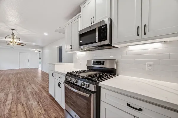 a kitchen with stainless steel appliances white cabinets and stove