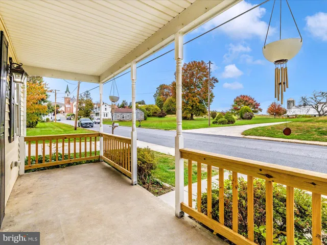a view of a porch with furniture and a yard