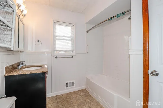 a bathroom with a tub sink and mirror