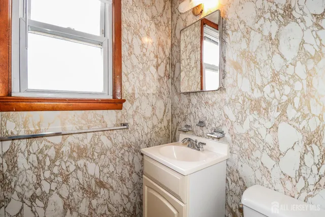 a bathroom with a sink and mirror with toilet