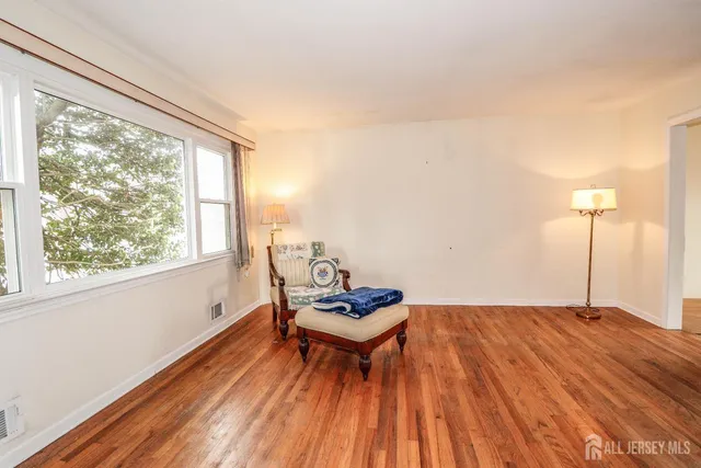 a living room with hard wood floors and a window