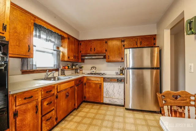 a kitchen with stainless steel appliances granite countertop a refrigerator a sink and dishwasher