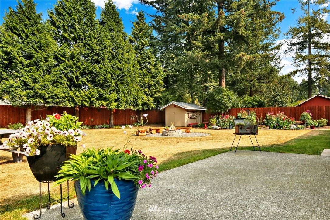 1064 West Laurel Road Ferndale, WA 98248 - Photo 25 of 39 a white house with a yard and a garden
