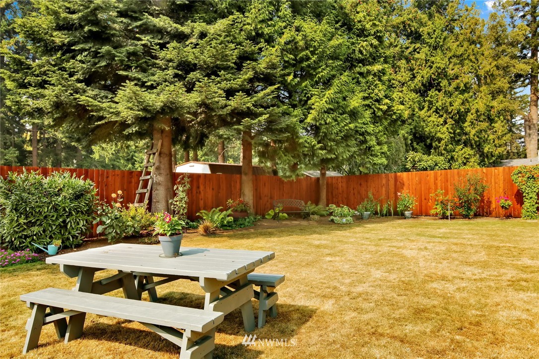 1064 West Laurel Road Ferndale, WA 98248 - Photo 28 of 39 a view of a patio with table and chairs with wooden fence and plants