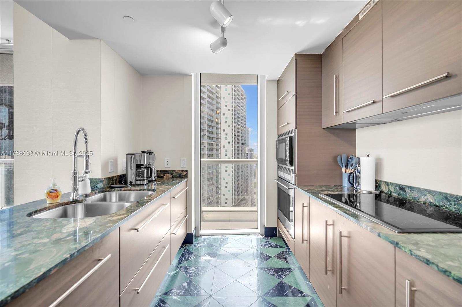 485 Brickell Avenue, Unit 2508 Miami, FL 33131 - Photo 8 of 20 a kitchen with granite countertop a sink and refrigerator