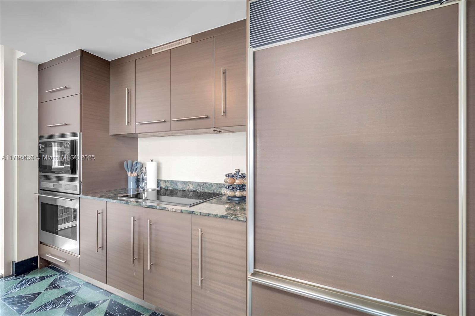 485 Brickell Avenue, Unit 2508 Miami, FL 33131 - Photo 9 of 20 a kitchen with cabinets and a refrigerator