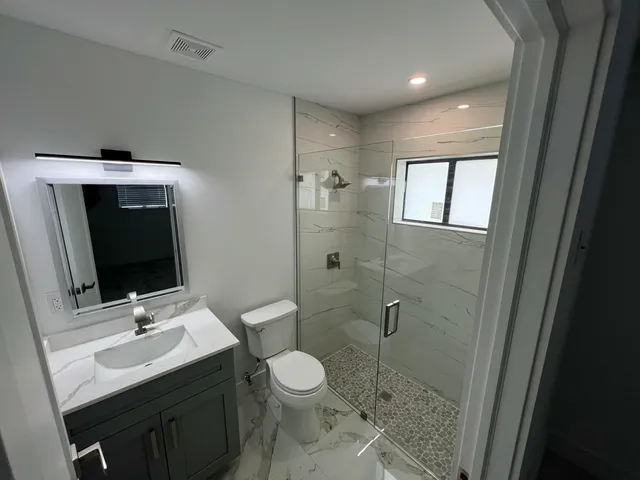 a bathroom with a sink toilet and shower
