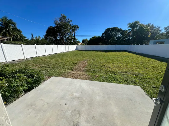 a view of a small house with wooden fence