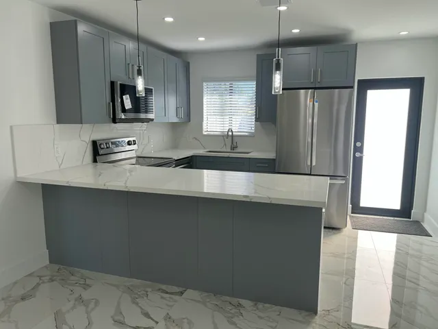 a kitchen with stainless steel appliances a refrigerator sink and microwave