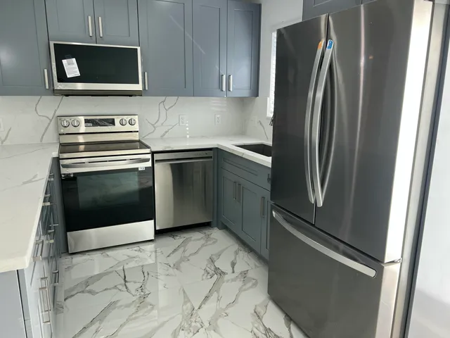 a kitchen with stainless steel appliances granite countertop a refrigerator and a microwave