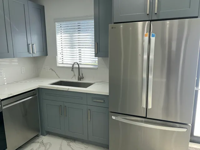 a kitchen with stainless steel appliances granite countertop a refrigerator and a sink