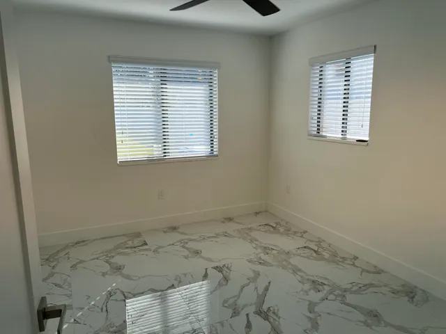 a view of an empty room with closet and a bathroom