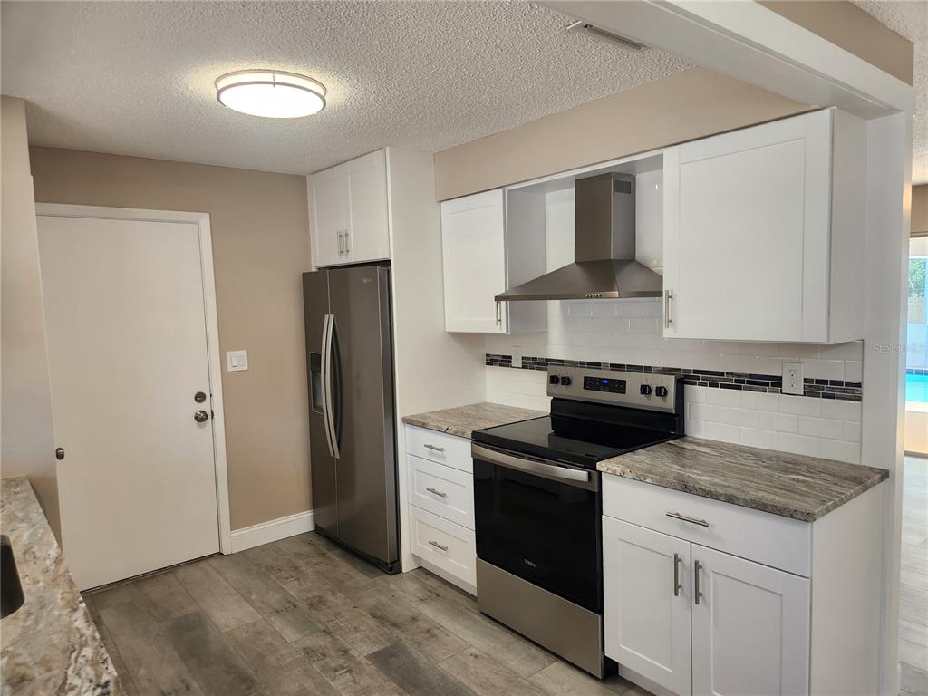 4462 Cynthia Lane Spring Hill, FL 34606 - Photo 3 of 22 a kitchen with stainless steel appliances granite countertop a stove and a refrigerator