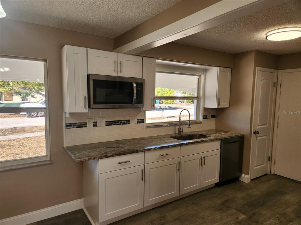 4462 Cynthia Lane Spring Hill, FL 34606 - Photo 4 of 22 a kitchen with a sink stove and microwave