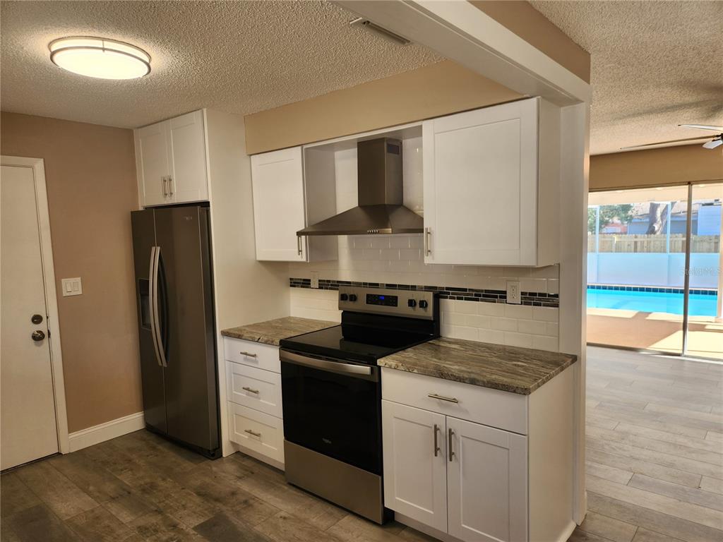 4462 Cynthia Lane Spring Hill, FL 34606 - Photo 5 of 22 a kitchen with a stove and a refrigerator