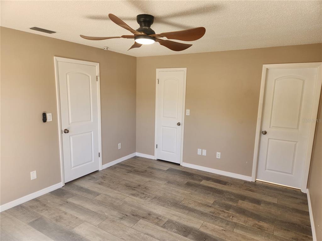4462 Cynthia Lane Spring Hill, FL 34606 - Photo 8 of 22 a view of a big room with wooden floor and a ceiling fan