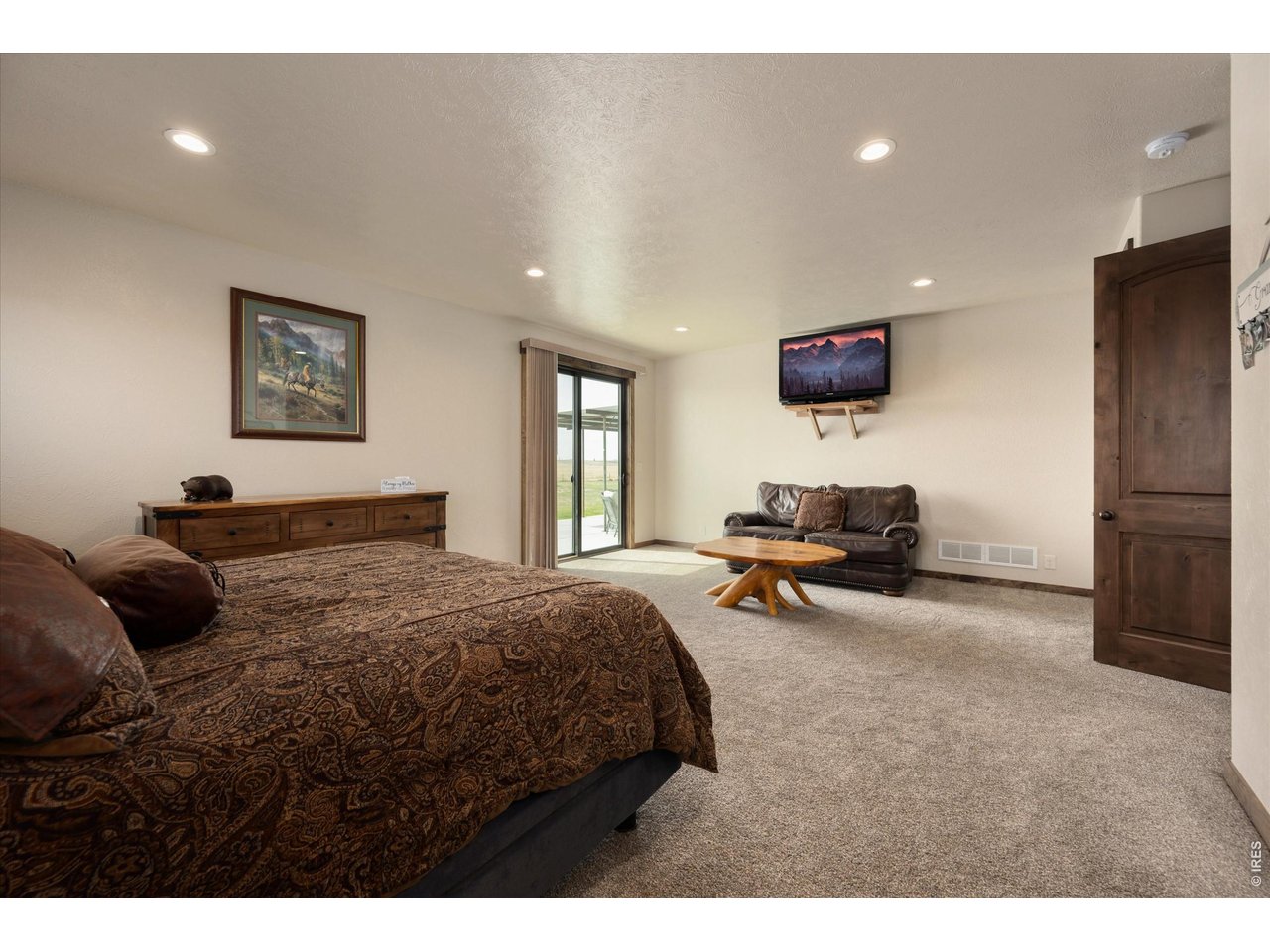 8626 County Road 22 Fort Lupton, CO 80621 - Photo 18 of 50 a bedroom with a bed a couch and a flat screen tv