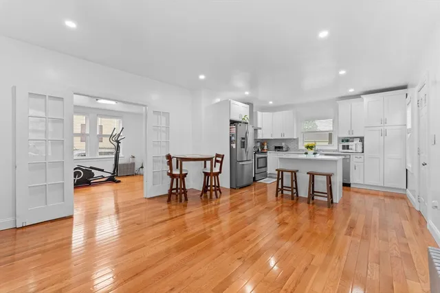 a view of kitchen with dining table chairs refrigerator and wooden floor