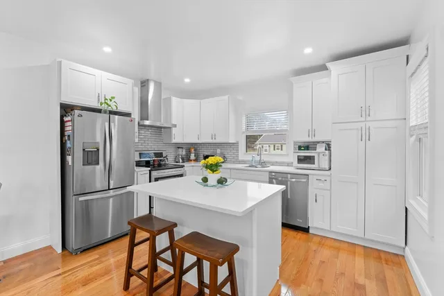 a kitchen with white cabinets and stainless steel appliances