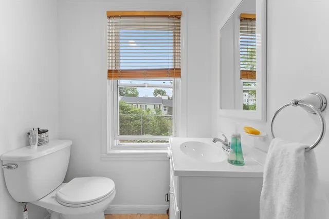 a bathroom with a toilet a sink and a window