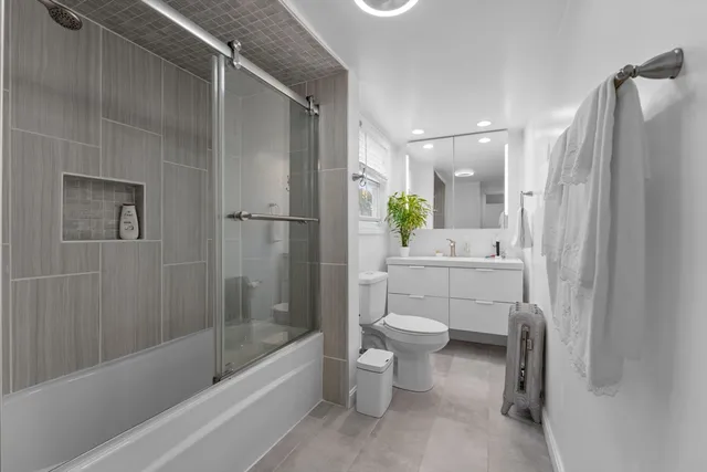 a bathroom with a bathtub shower sink and toilet