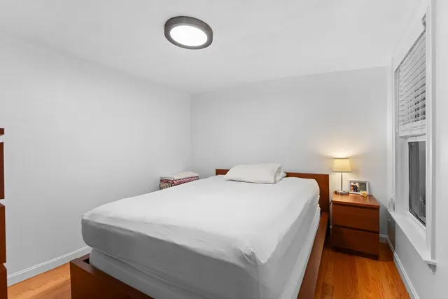 a bedroom with a bed and a large window