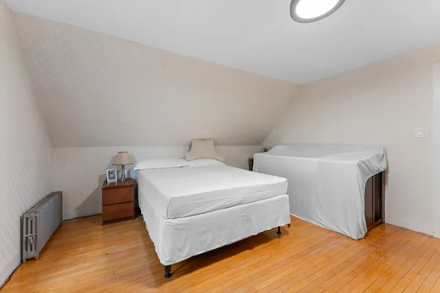 a white bed sitting in a bedroom next to a window