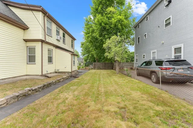 a view of a house with car parked on the road