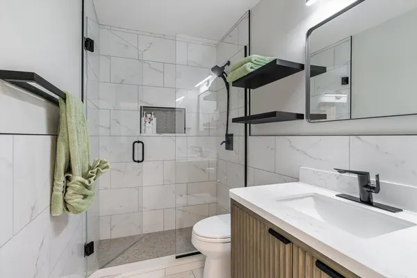 a bathroom with a sink a toilet and shower