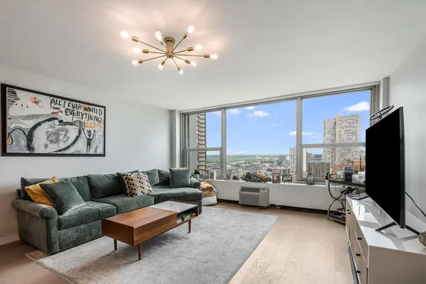 a living room with furniture ceiling fan and a flat screen tv