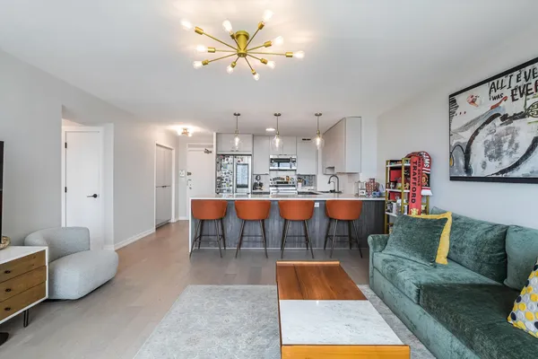 a living room with furniture and a dining table with kitchen view