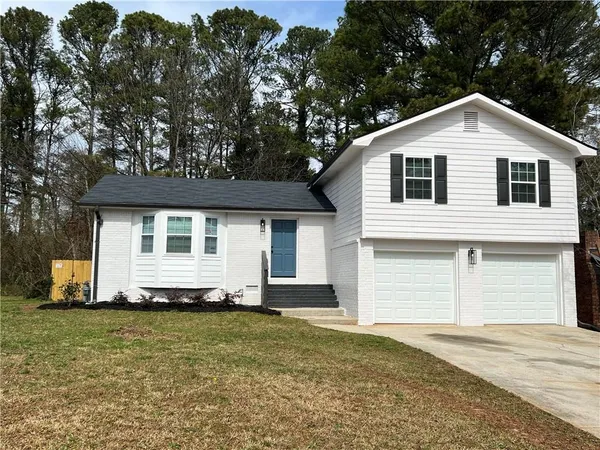 a view of a white house with a yard