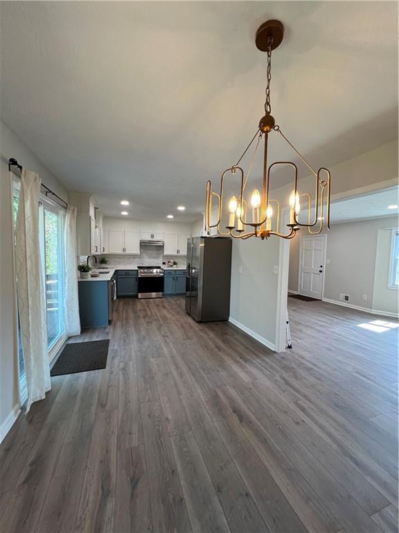 5990 Wellborn Trace Lithonia, GA 30058 - Photo 15 of 56 a view of a room with wooden floor kitchen view and a chandelier