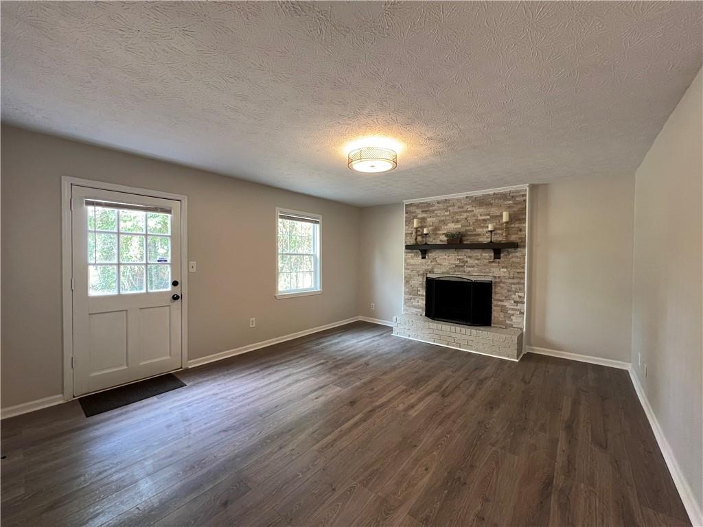 5990 Wellborn Trace Lithonia, GA 30058 - Photo 40 of 56 an empty room with wooden floor a fireplace and windows