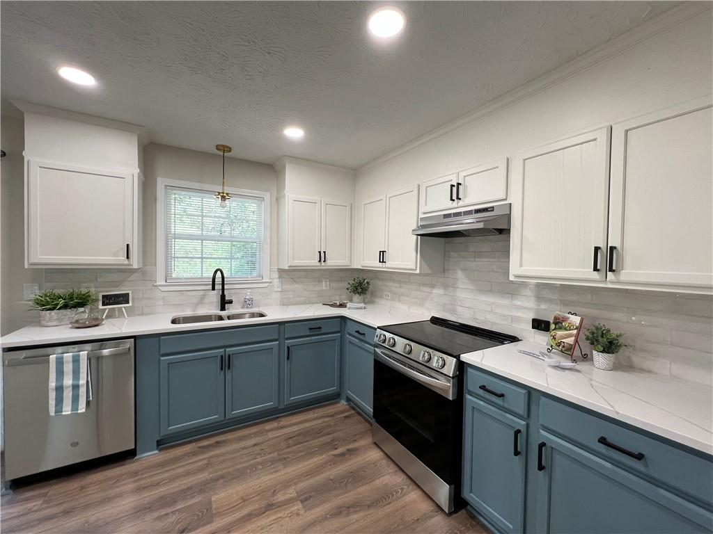 5990 Wellborn Trace Lithonia, GA 30058 - Photo 5 of 56 a kitchen with stainless steel appliances granite countertop a sink stove and cabinets