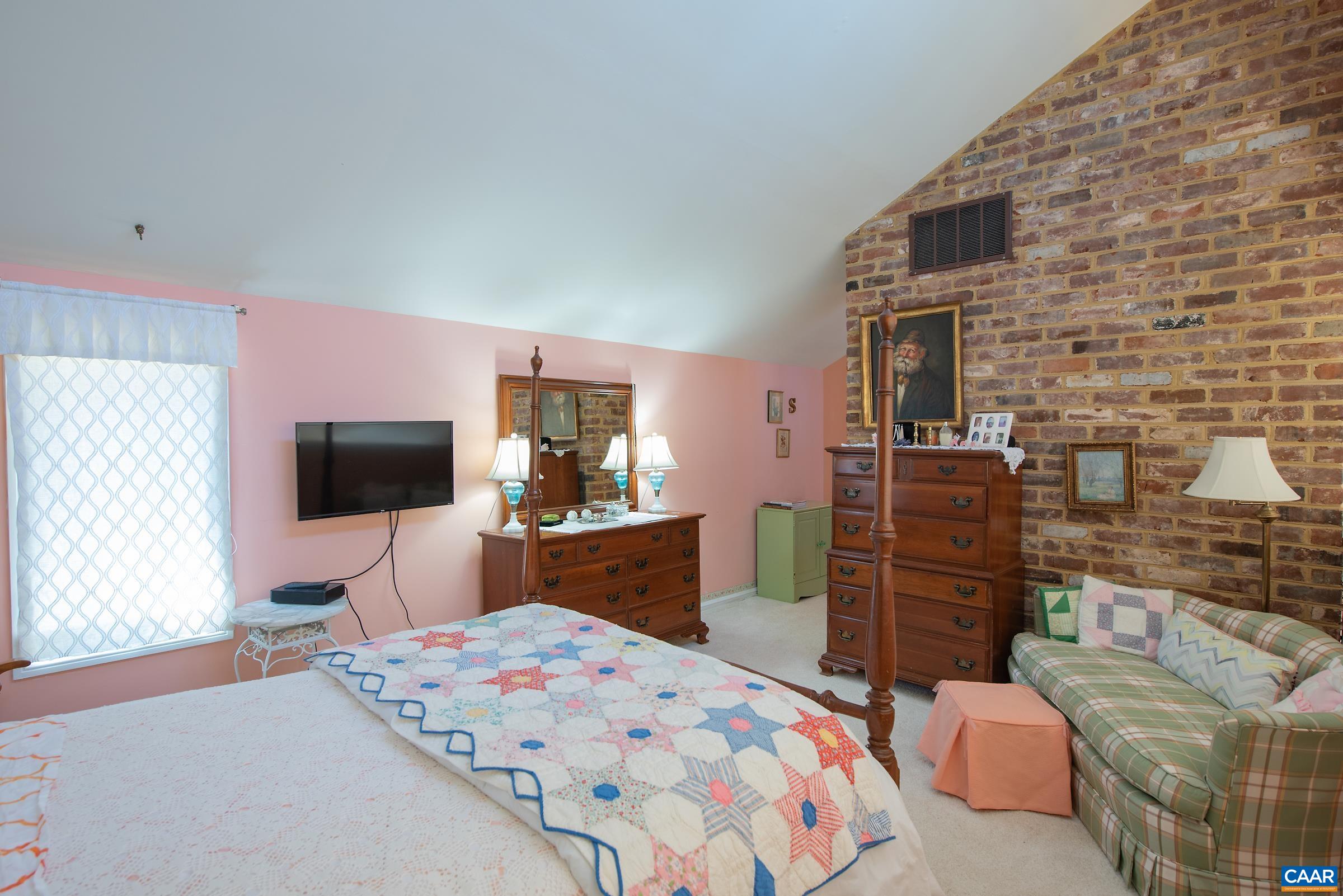 659 Broomley Road Charlottesville, VA 22901 - Photo 16 of 32 a bedroom with a bed and a flat screen tv